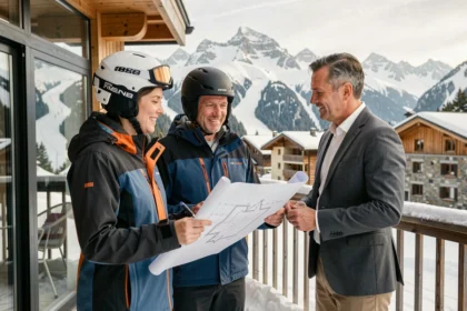 Couple et agent immobilier discutant d'un investissement dans un chalet aux Menuires avec les pistes de ski en arrière-plan
