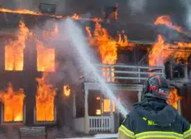 pompier éteignant une maison en feu